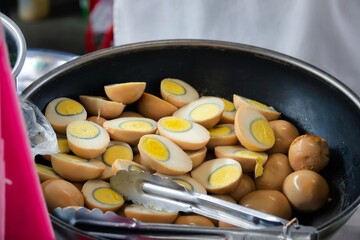 A large bowl of eggs with a silver spatula in it