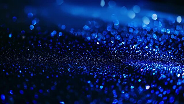 Tiny grains of sand ling like stars in the dark as a tropical blue glow emanates from the ground.