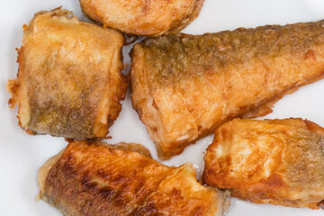 Fried hake pieces on dish close-up in selective focus