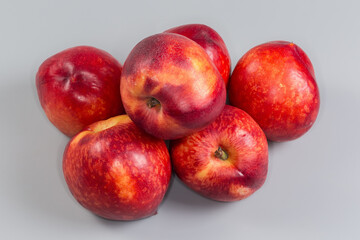 Heap of ripe nectarines on a gray background close-up