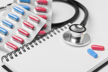 stethoscope equipment and psychotherapy pills modern capsule pink and blue healthy on notebook