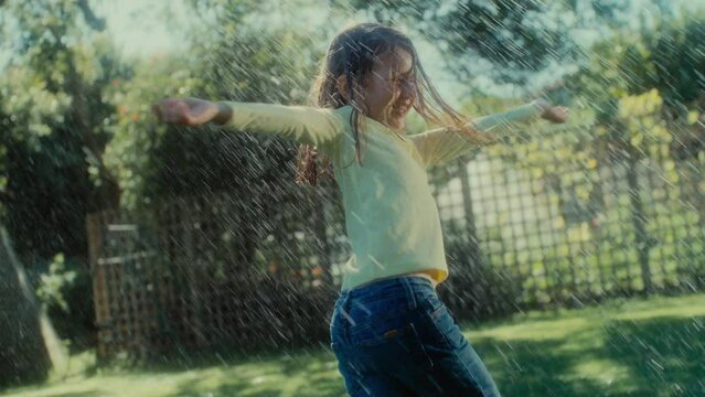Girl wet in the rain playing and dancing