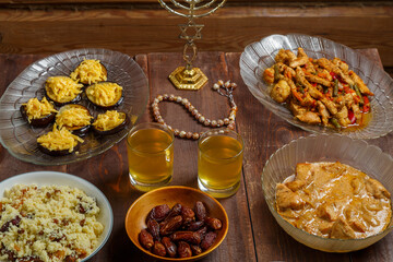 Shabbat table for family dinner with traditional holiday dishes on the table, rosary and menorah