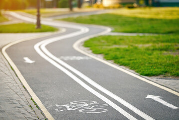 Bicycle lane sign, curvy marked bike lane winding through park. Winding bicycle lane in green...