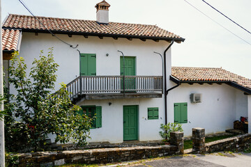 old white house with green doors and shutters