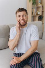 Dental health problems concept. Man suffering from strong toothache. Upset male patient with...
