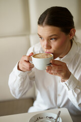 Elegant woman drinking a cappuccino in a bar