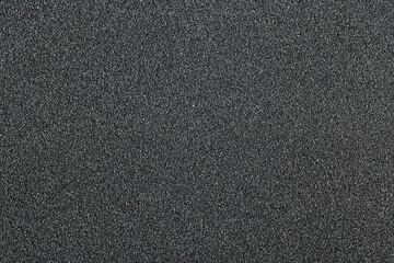 Pile of black quartz sand as background, top view. Crushed quartz.