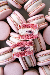 Texture inside of a macaron. French dessert macaron filled with white chocolate and blueberry ganache, and blueberry confit. Macarons are on a dark background. Top view. 