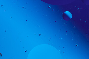 Serene abstract image with various sized blue and purple bubbles on dark blue background, creating calm visual effect.