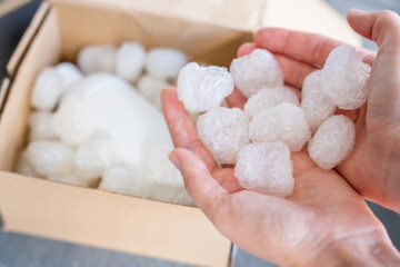 Eco packaging of parcels and white biodegradable filler. Box is filled with a filler safety for environment. Delivery of goods, parcels, delivery service, nature protection and recycling concept