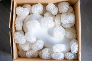 Eco packaging of parcels and white biodegradable filler. Box is filled with a filler safety for environment. Delivery of goods, parcels, delivery service, nature protection and recycling concept