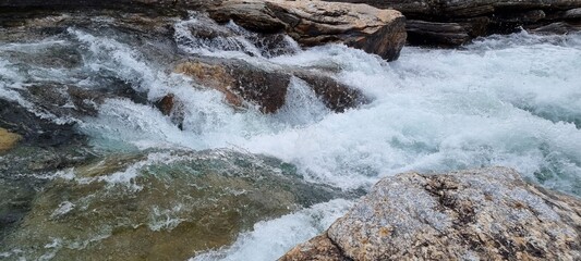 Rapid flowing mountain river through forest in summer