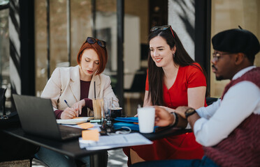 Businesspeople engaged in a meeting while sitting at an outdoor cafe, discussing strategies with a laptop on the table.