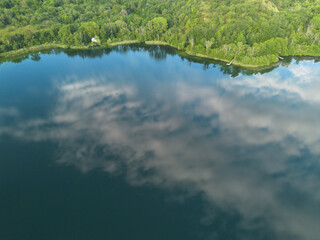 Reflets du ciel et des nuages sur le lac de Chavoley, sur la commune de Ceyzérieu, dans l'Ain en France à la fin du printemps