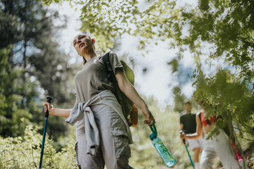 Group of friends trail hiking through a verdant forest on a sunny day, enjoying outdoor adventure and nature.