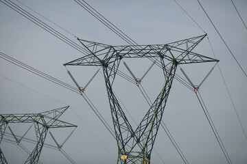 High Voltage Electric Transmission Tower. Interesting angle of an electricity pylon, showing wires and insulator details. A tower with high voltage cables