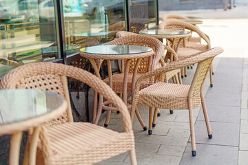 Synthetic wicker furniture adorns a street restaurant, offering a stylish outdoor dining experience