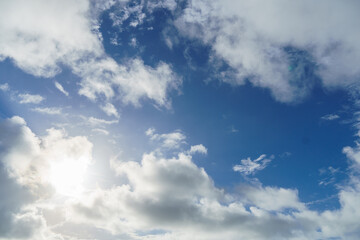 The sun shines through the clouds in a blue sky landscape