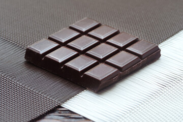 Dark chocolate. Broken chocolate bar on kitchen table
