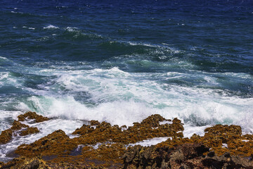 Spectacular natural beauty of waves crashing against the rugged rocky shoreline of Aruba's Caribbean coast.