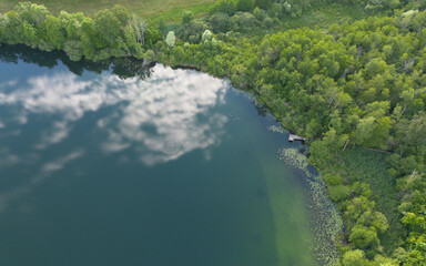 Reflets du ciel et des nuages sur le lac de Chavoley, sur la commune de Ceyz&eacute;rieu, dans l'Ain en France &agrave; la fin du printemps