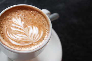 Cup of cappuccino close-up on a black. Latte art