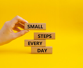 Small Steps Every Day symbol. Wooden blocks with words Small Steps Every Day. Beautiful yellow...