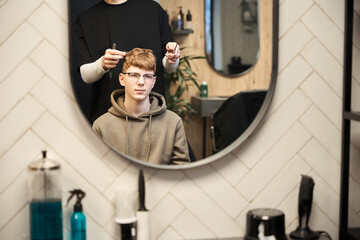 Photo of young male visitor in hairdressing salon