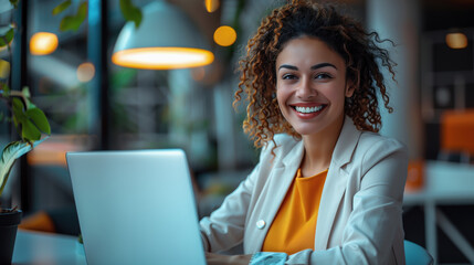 Young and beautiful business woman, using a laptop, working in a modern office