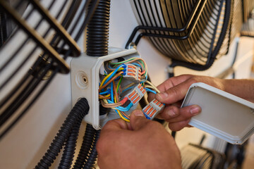Electrician fixing complex wiring in junction boxes, showing expertise in electrical systems