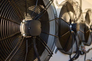 Industrial Cooling Fans mounted on a wall with ventilation equipment and machinery in closeup focus