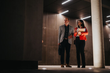 Young corporate business partners engaged in a serious discussion in a modern office setting during night time.