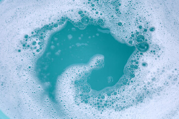 Detergent foam bubble on water. Blue background, Soap sud