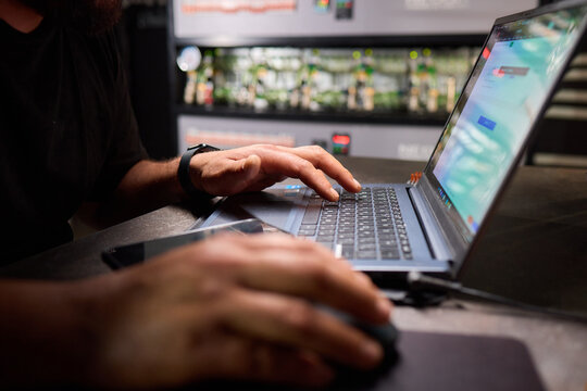 Professional working on a laptop in tech environment surrounded by technological equipment