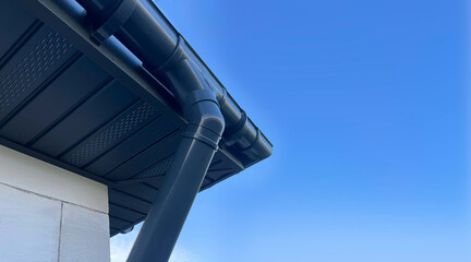 Obraz premium Installation of a drainage system on the house, lining the canopy with gray clapboard.