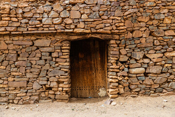 Fototapeta premium door of an old castle and architecture of stones buildings in a village in the south of the Kingdom of Morocco in the Souss-Massa region