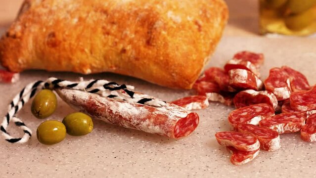 Spanish tapa Fuet sausage slices. Ciabatta, olives, tomato juice, cherry tomatoes. Spanish snacks for wine