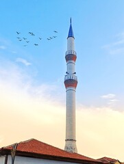 a large mosque with birds flying around it