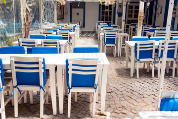 Empty, white tables with blue cushions in a fish restaurant