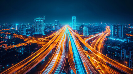 Obraz premium A futuristic cityscape illuminated by vibrant orange and blue highway lights at night. The dynamic light trails, highlighting the urban architecture and modern infrastructure