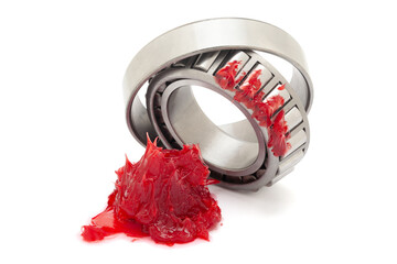 Two tapered roller bearings with red lithium grease (Machinery Lubrication). Isolated on a white...