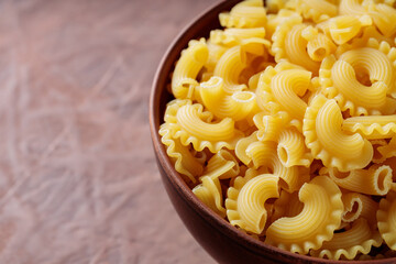 Traditional Italian Pasta Creste di Gallo in Shape of Rooster's Comb in Clay Bowl, Copy Space