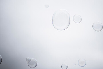 Large multicolored soap bubbles flying in the cloudy sky. Big bubble outdoors in the spring or summer street. Many bubbles isolated on white background. Simple creative concept. Close-up. Copy space