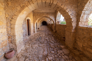 Europe, Greece, Crete, Rethymno. Venetian Baroque, 16th C. Eastern Orthodox Monastery.  The Holy Monastery of Arkadi. Arched stone passageway.