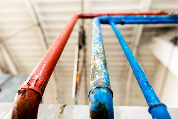 vecchi tubi lunghi rossi e azzurri, con segni di usura, che si estendono verso l'alto all'interno...