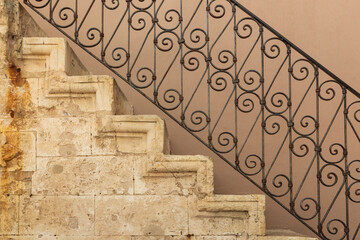 Stone staircase with ornate wrought iron balustrade. Europe, Greece, Crete, Chania.