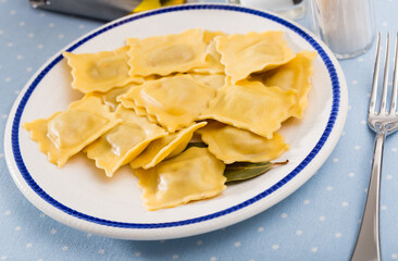 Plate of appetizing freshly boiled ravioli garnished with herbs