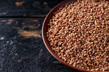 Raw Buckwheat Grains on Clay Plate, Copy Space