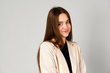 Young Woman in White Jacket and Black Pants on Gray Background.